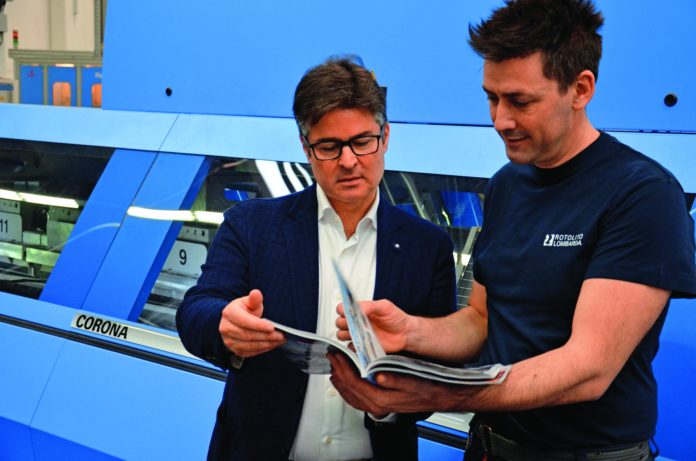 PM02-2017_S13_B Il direttore della legatoria Matteo Quadri (a destra) mostra a Fabio Casale di Müller Martini Italia un catalogo appena brossurato sulla Corona.