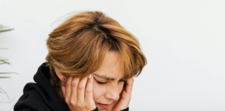 Acufeni, approccio integrato Donna che si copre le orecchie a causa di acufene o tinnito