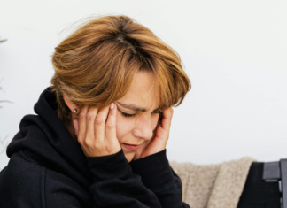 Acufeni, approccio integrato Donna che si copre le orecchie a causa di acufene o tinnito