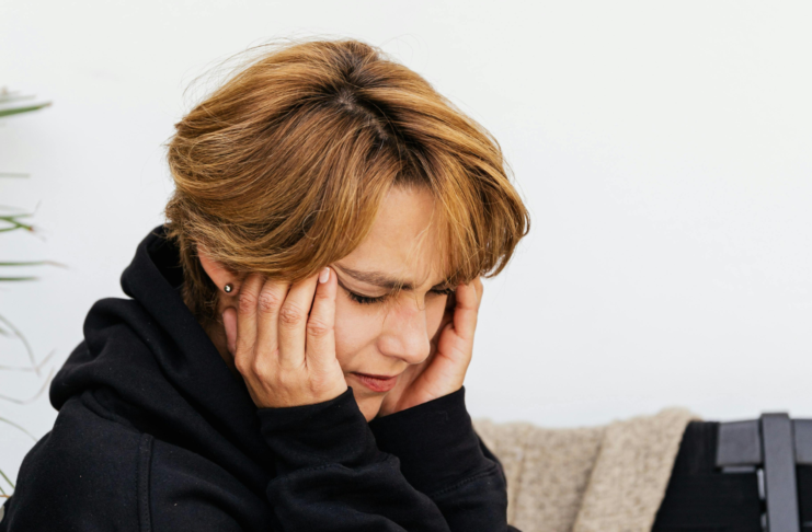 Acufeni, approccio integrato Donna che si copre le orecchie a causa di acufene o tinnito