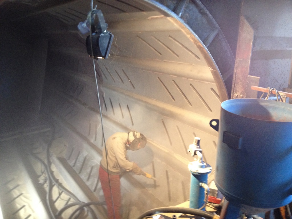 Grit blasting the de-barker drum prior to application of abrasion resistant lining.