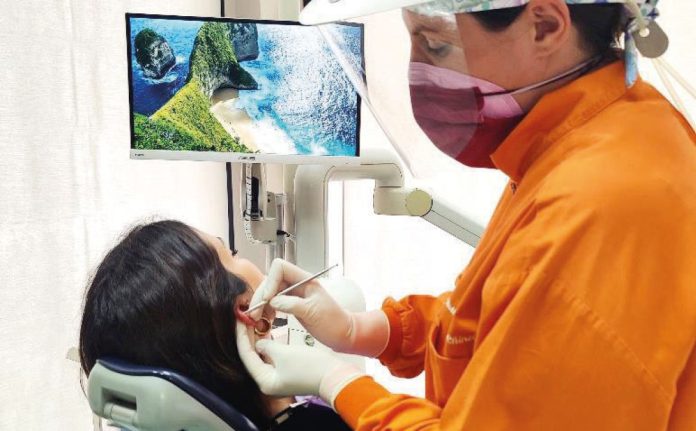 Fig. 1 Applicazione dell’auricoloterapia preseduta d’igiene orale professionale.