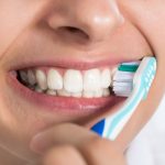 Woman Brushing Teeth At Home