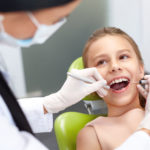 Teeth checkup at dentist’s office. Dentist examining girls teeth
