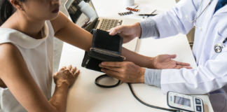 Donna che si fa misurare la pressione sanguigna dal medico