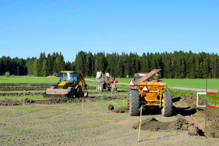 Tractors and excavator on the field making a drainage. espropri