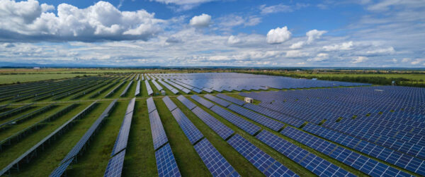 Aerial view of big sustainable electric power plant with many rows of solar photovoltaic panels for producing clean electrical energy. Renewable electricity with zero emission concept