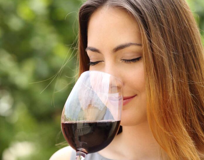 Somelier woman smelling red wine